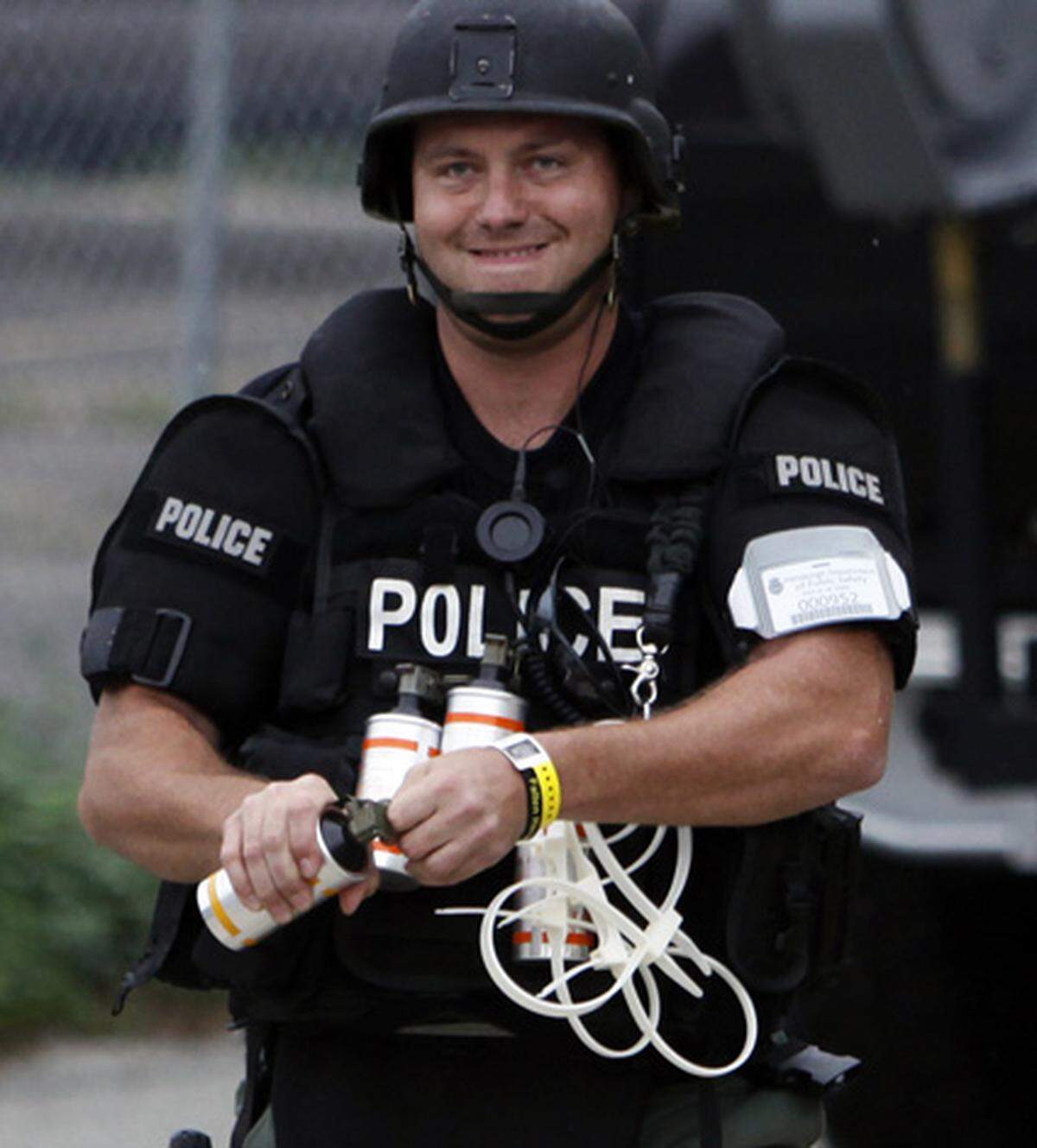 Ein Polizist bereitet eine Tränengasgranate vor. Die weißen Kabelbinder sind für allfällige Verhaftungen.