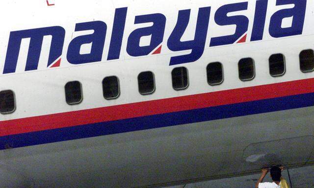 A MALAYSIAN AIRLINE EMPLOYEE INSPECTS AN AIRCRAFT AT KUALA LUMPURINTERNATIONAL AIRPORT.
