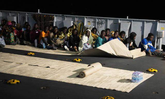 Migranten sitzen an Deck eines Rettungsschiffs im Hafen der italienischen Insel Lampedusa, am 16. September 2023.