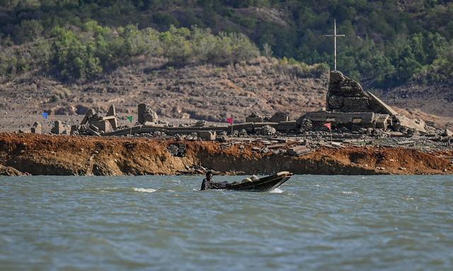 Ein Boot vor den wiederaufgetauchten Ruinen von Pantabangan.