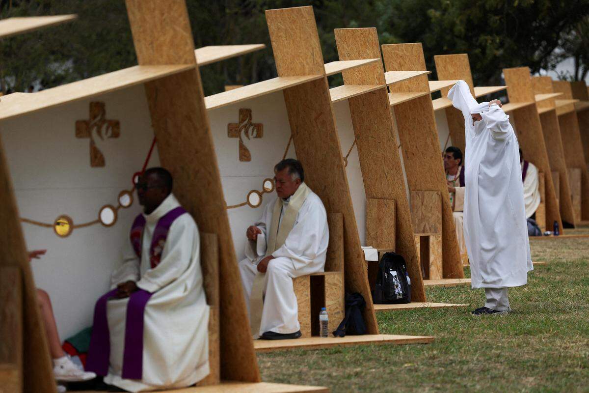 2. August. Ein Priester wechselt ins Arbeitsgewand bei einer Beichtstation in Lissabon während des katholischen Weltjugendtags. 
