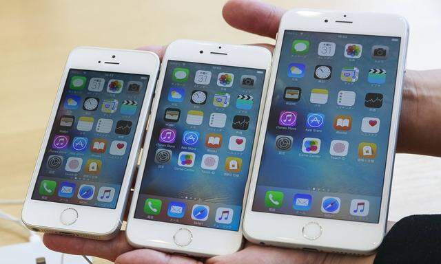 L to R A woman shows the new iPhone SE iPhone 6S and iPhone 6S Plus at Apple Store in Omotesando