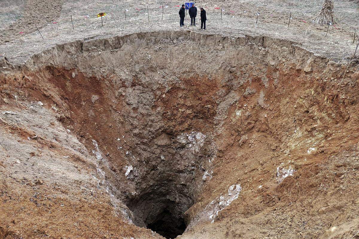 Ein Loch mit 24,9 Metern Durchmesser hat sich in einem Dorf in der Sichuan-Provinz in China aufgetan. Lokale Medien berichteten, dass der Karst-Boden die Tage zuvor absank. Starker Regen könnte das Loch dann verursacht haben. Aufnahme vom 28. Februar 2013.