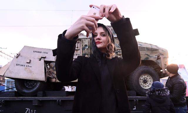 Ein Selfie vor der Kriegstrophäe: Eine junge Frau fotografiert sich vor einem in Syrien erbeuteten Humvee-Geländewagen in der südrussischen Stadt Rostow am Don. 