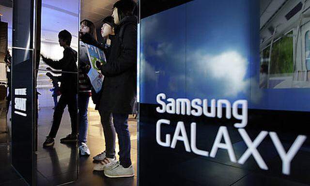 Students look at the huge screen of  Samsung Electronics Co. at a showroom of its headquarters in Seo