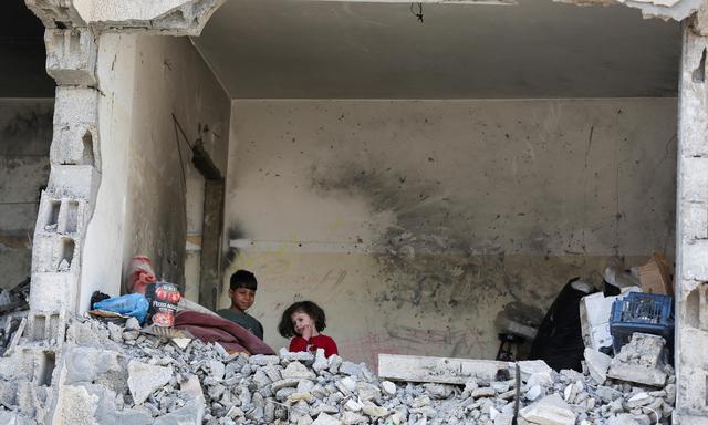 Palästinensische Kinder in einem zerstörten Haus in Rafah. 