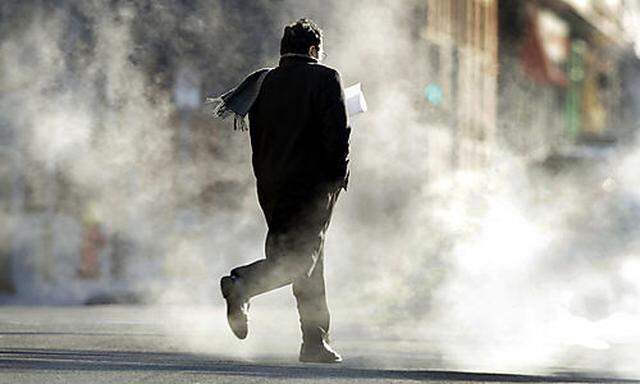 A man hurries across a chilly street as steam rises from below Tuesday, Jan. 5, 2010, in St. Louis. B