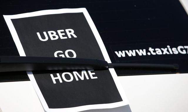 A leaflet which reads 'Uber go home' is seen on a taxi as striking French taxi drivers block the traffic on the Paris ring road during a national protest against car-sharing service Uber, in Paris