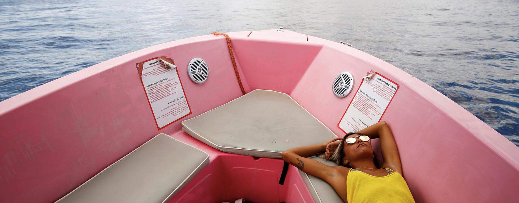 A woman sunbathes on a boat sailing in the Red Sea, off Eilat´s shore