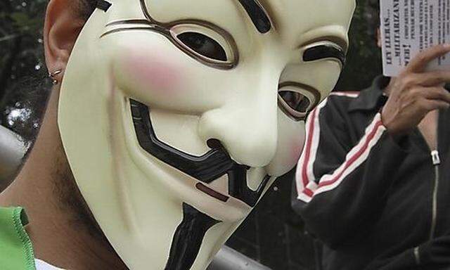 A protester wearing a Fawkes mask, symbolic of the hacktivist group Anonymous, takes part in a prot