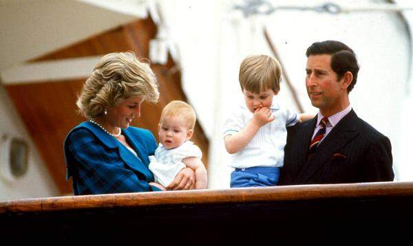Prinz Harry wird  also zum ersten Mal Vater - „im Frühling“, wie der Kensington-Platz verlautbaren ließ. Es kann sich also nur noch um wenige Wochen oder Tage handeln, bis bei Herzogin Meghan, die sich bereits in der Babypause befindet, die Wehen einsetzen. Auf diesem Bild ist Prinz Harry gut behütet als Baby in den Armen von seiner Mutter, Prinzessin Diana, zu sehen. Bruder William und Papa Charles komplettieren das Familienfoto aus dem Jahr 1985.