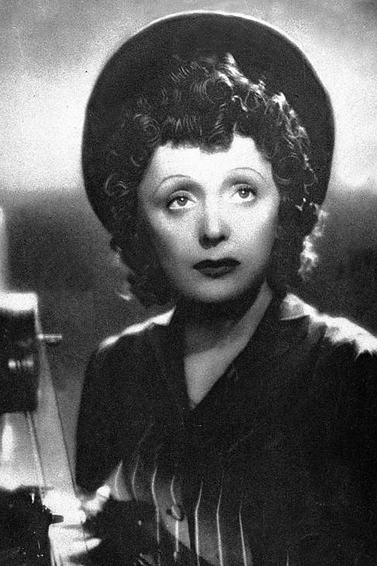 Die Legende besagt, dass Piaf am 19. Dezember 1915 auf der Straße geboren wurde. Sie erzählte diese Mär selbst gerne. Tatsächlich kam sie im Pariser Tenon-Krankenhaus unter dem Namen Edith Giovanna Gassion zur Welt. Ihre Eltern, ein Zirkusartist und eine Sängerin, schickten sie zu den Großeltern in die Normandie. Mit 15 Jahren kam sie nach Paris zurück und wurde Straßenmusikantin.