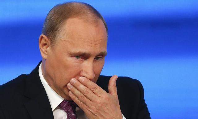 Russian President Putin reacts during his annual end-of-year news conference in Moscow
