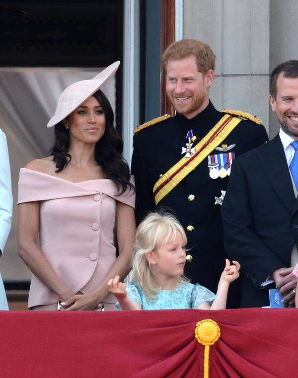 Das blassrosa Kostüm mit großen Knöpfen und weitem Ausschnitt kombinierte die Herzogin von Sussex mit einem Hut von Philip Treacy.