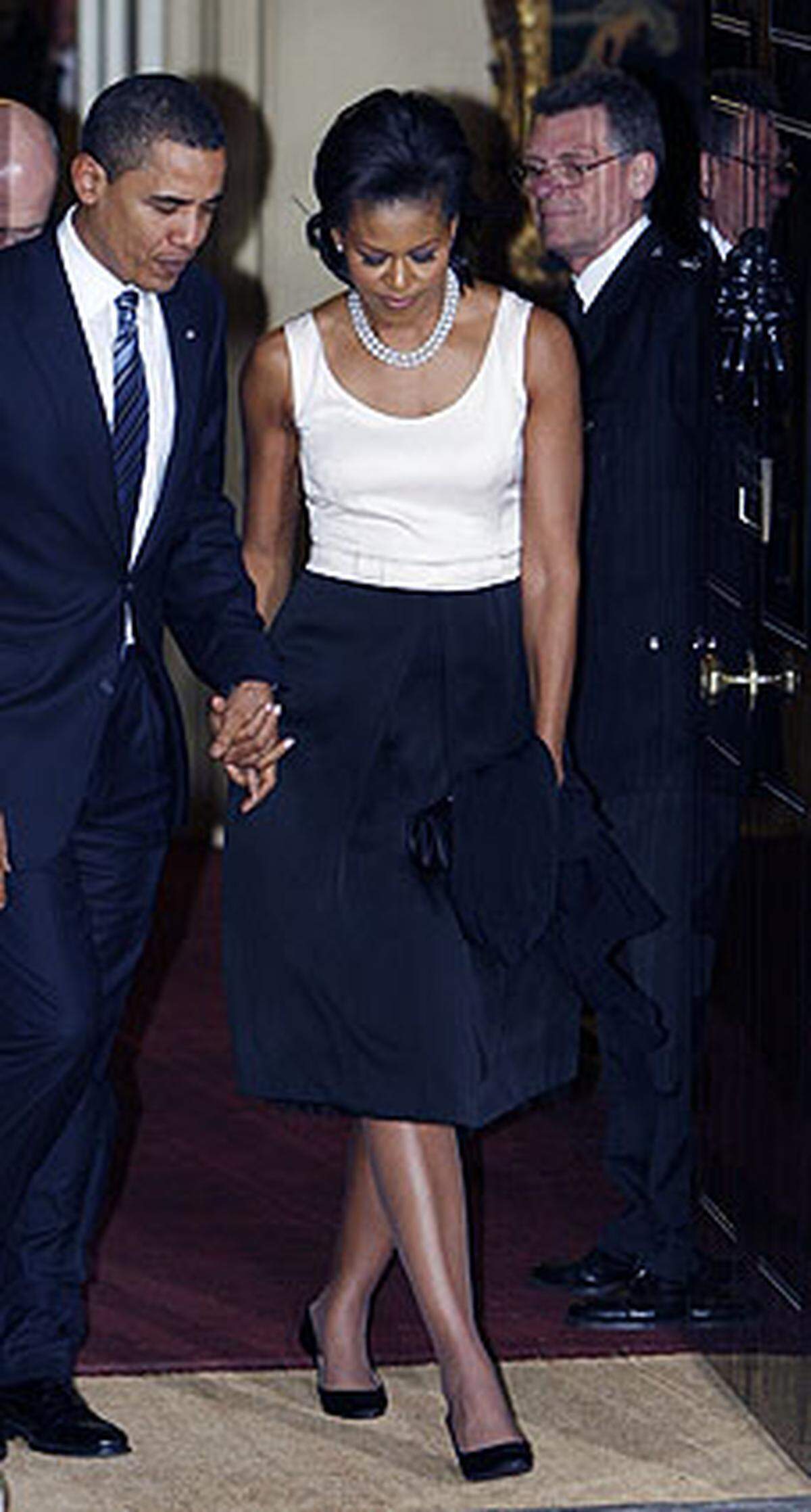 Obamas Outfit sei "frühlingshaft" und "mutig" gewesen und vermittle Optimismus, urteilten Experten.  Nach dem Dinner war der Frühling wieder vorbei - Michelle Obama in einer eleganten aber nicht zugeknöpften Schwarz/Weiß-Kombi. 