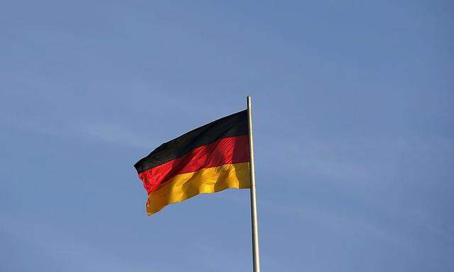 A German national flag is seen atop the Reichstag building, the seat of the German lower house of parliament Bundestag, in Berlin