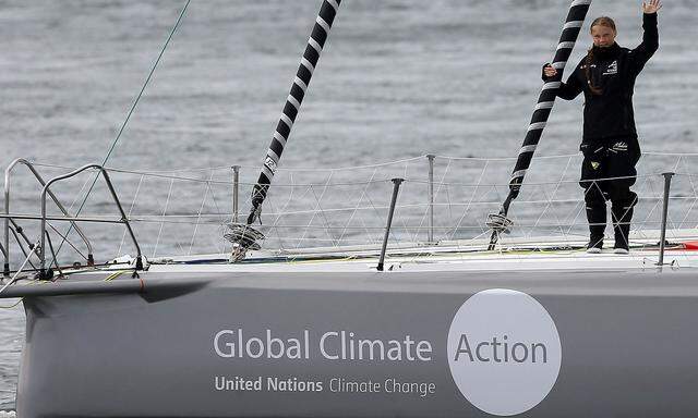 Swedish teenage climate activist Greta Thunberg waves from a yacht as she starts her trans-Atlantic boat trip to New York, in Plymouth