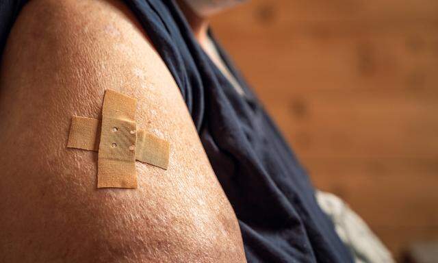 Mindelheim, Bavaria, germany - 01 may 2021: overweight woman shows her arm after being vaccinated. arm with adhesive ba