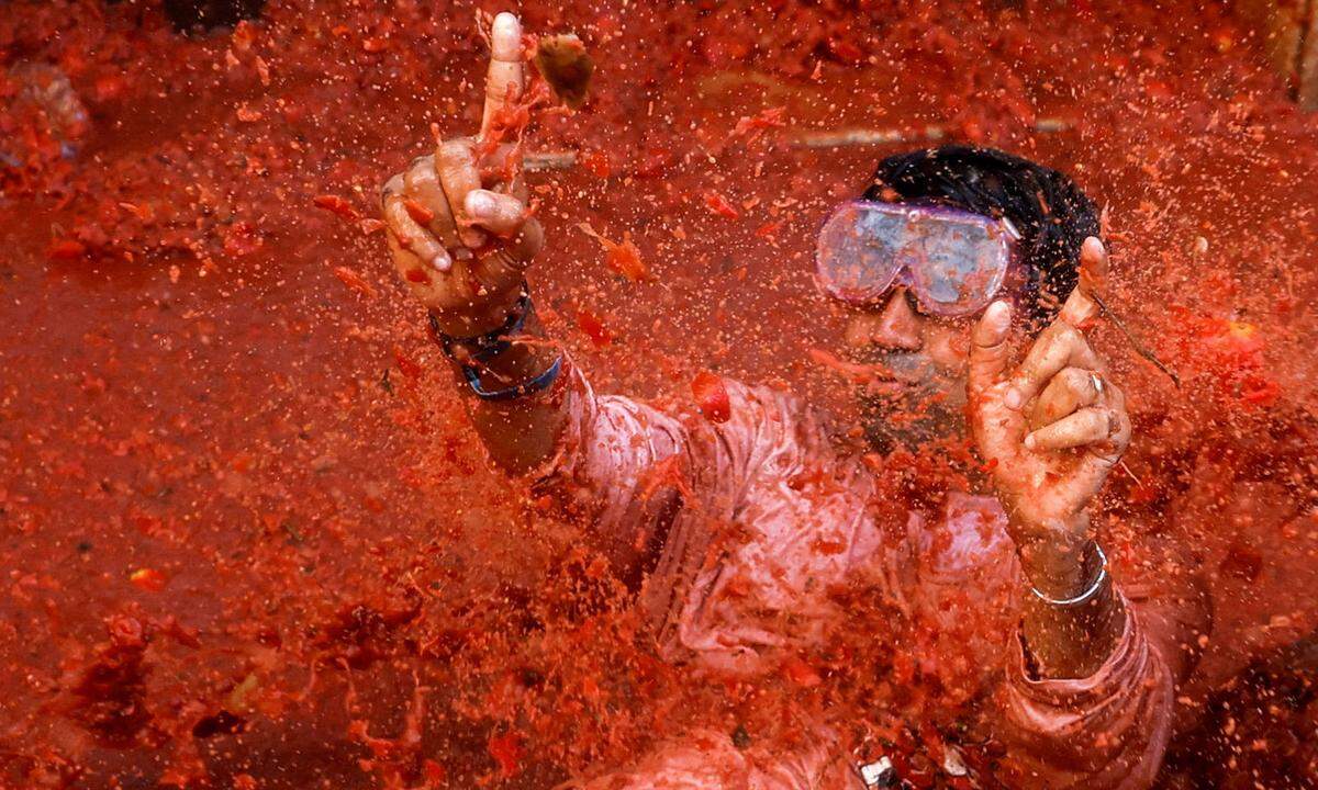 31. August. Ein Feiernder hat während der jährlichen Tomatenschlacht "La Tomatina" in Bunol, Spanien, offenbar seinen Spaß.