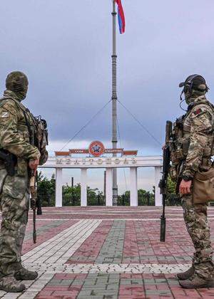 Russische Soldaten auf einem Platz in Melitopol in der besetzten Südukraine, dahinter die Fahne Russlands. In der Gegend wuchs zuletzt die Partisanenaktivität. 