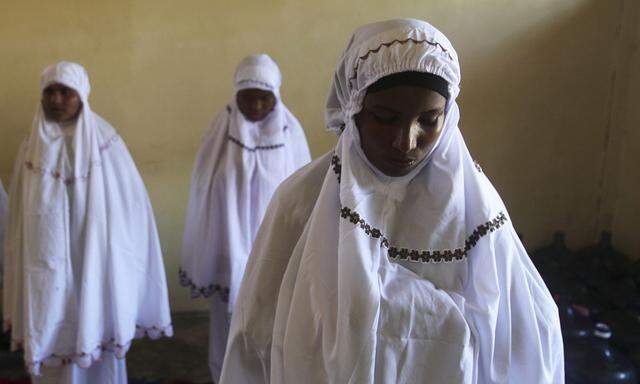 Rohingya migrant women, who recently arrived in Indonesia by boat, attend a mid-day mass prayer session inside a shelter in Kuala Langsa