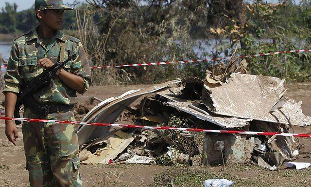 Soldier guards the crash site of an ATR-72 turboprop plane in Pakse town