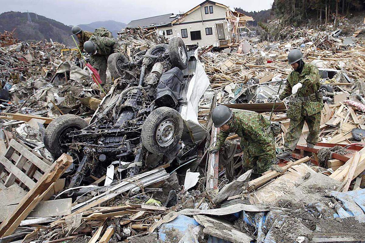 Dienstag (15. März): Japanische Einsatzkräfte suchen in den Überresten des Ortes Rikuzentakata nach Überlebenden.
