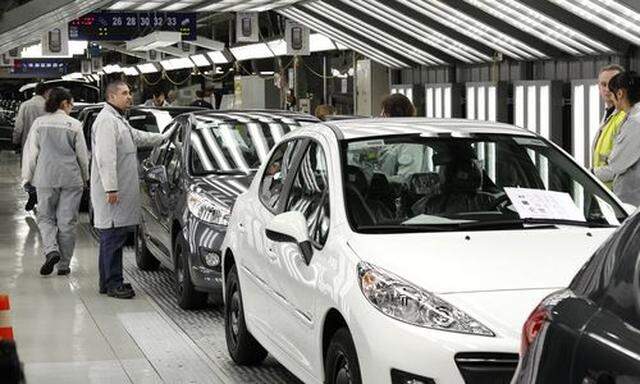 File photo of an employee working on the assembly line of the Peugeot 207 at the PSA Peugeot Citroen plant in Poissy