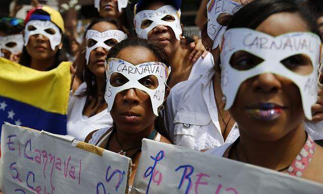 Opposition demonstrators wearing carnival masks take part in a women's rally against Nicolas Maduro's government in Caracas