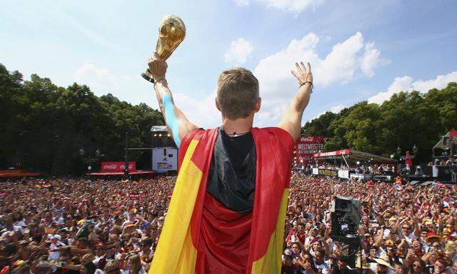 Germany´s Schweinsteiger  holds up the World Cup trophy during celebrations to mark the team´s 2014 Brazil World Cup victory in Berlin