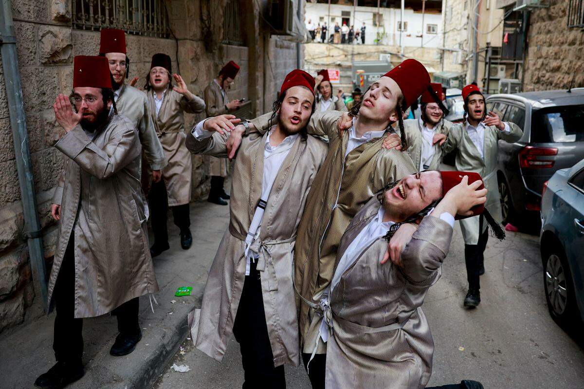 25. März. Ultra-orthodoxe jüdische Männer feiern das Purim-Fest in Jerusalem.