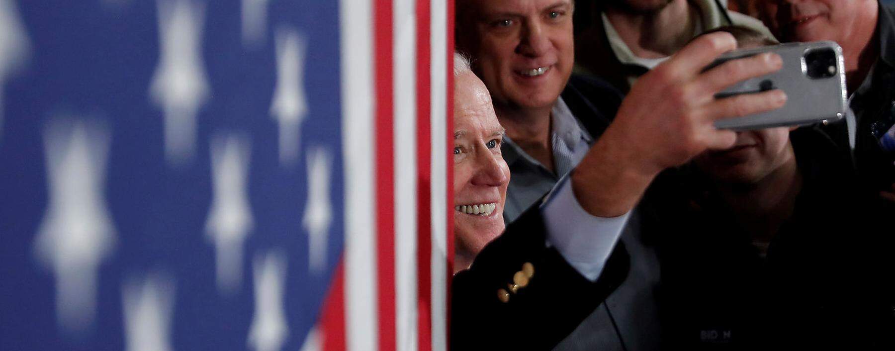 Biden poses for a pictures with supporters during a campaign event in Manchester, New Hampshire