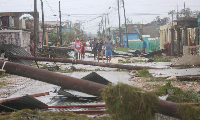 People walk on a damaged street after the passage of Hurricane Irma in Caibarien, Cuba
