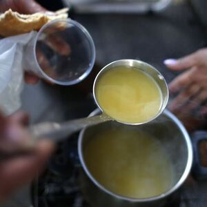 Spanish Luis Dominguez Quintana, a member of the Mortgage Victims' Platform, puts vegetable soup in a plastic cup outside the nationalized lender Bankia bank headquarters in Madrid