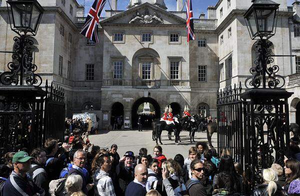 Solange es keine weißen Kleider und wilde Hüte zu sehen gibt, schenken die angereisten Touristen der Wachablöse vor dem Buckingham Palast ihre Aufmerksamkeit.