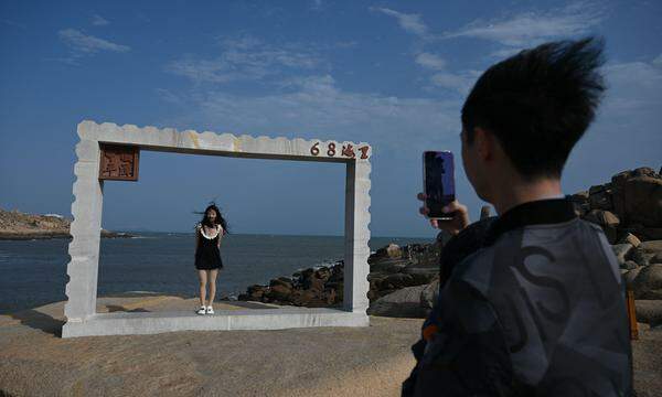 Der Blick vom chinesischen Festland aus auf die Taiwan-Straße. Ein Mann macht auf der Insel Pingtan in der chinesischen Provinz Fujian, dem nächsten Punkt zur taiwanischen Küste, ein Foto.