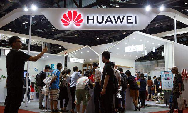 People look at products at the Huawei stall at the International Consumer Electronics Expo in Beijing