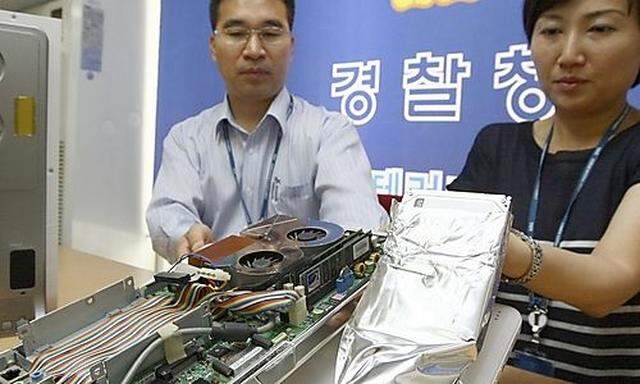 Ein beschlagnahmter PC in Händen der Polizei in Südkorea