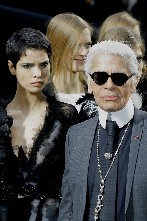 Der Grundtenor ist düster gehalten, die Models entsteigen einer Staubwolke und defilieren über ein Betonkonstrukt, Schotter und Teer. Statt der filigranen High Heels empfiehlt der Modepapst, derbe Boots mit reichlich Profil.