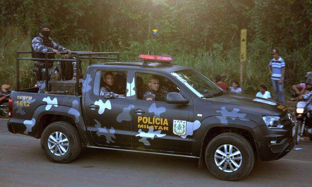 Ein Polizeiauto patrouilliert in der Nähe von Familien und Verwandten der Gefangenen des Gefängnisses