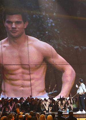 Actor Taylor Lautner accepts the award for best shirtless performance at the 2013 MTV Movie Awards in Culver City, California