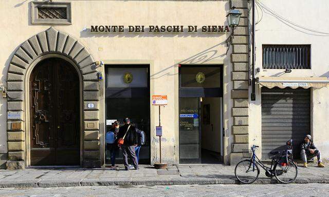 People use a cash machine of Monte Dei Paschi bank in downtown in Florence