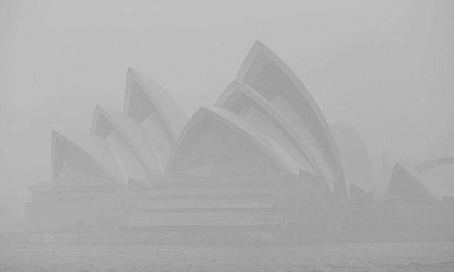 Willkommen in der Gegenwart: die Oper von Sydney hinter Rauchschwaden.