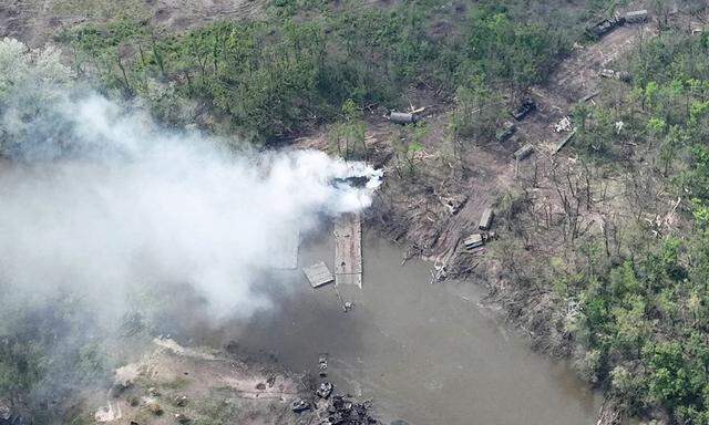 Smoke rises from a makeshit bridge across the Siverskyi Donets River