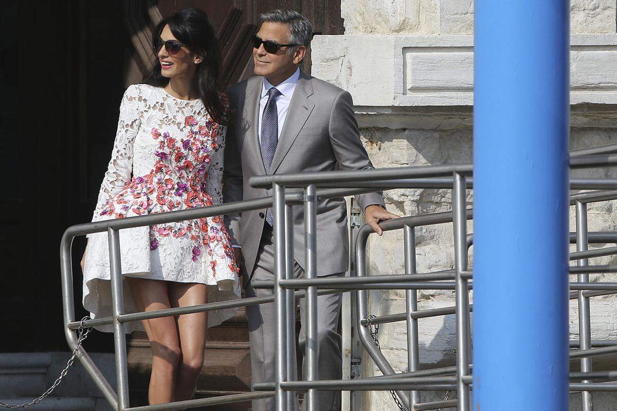 Clooney zeigte sich in einem hellgrauen Anzug, Alamuddin trug ein elegantes kurzes Spitzenkleid mit Rosen in Pastellfarben.