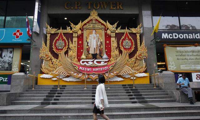 A woman walks outside the CP Tower in Bangkok