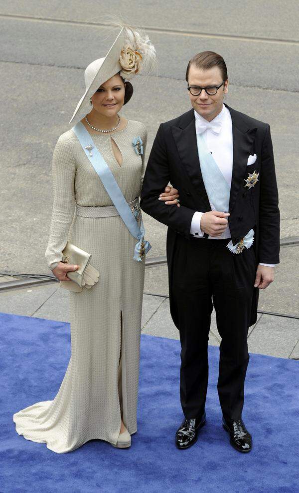 Kronprinzessin Victoria von Schweden an der Seite von Ehemann Prinz Daniel entschied sich für ein beige-goldenes Kleid und einen üppigen Hut.