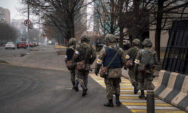 Kasachische Soldaten patroullieren auf einer Straße in der Metropole Almaty.