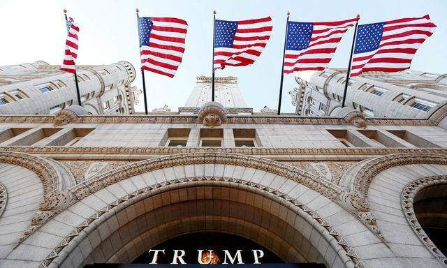 FILE PHOTO - Flags fly above the entrance to the new Trump International Hotel on its opening day in Washington