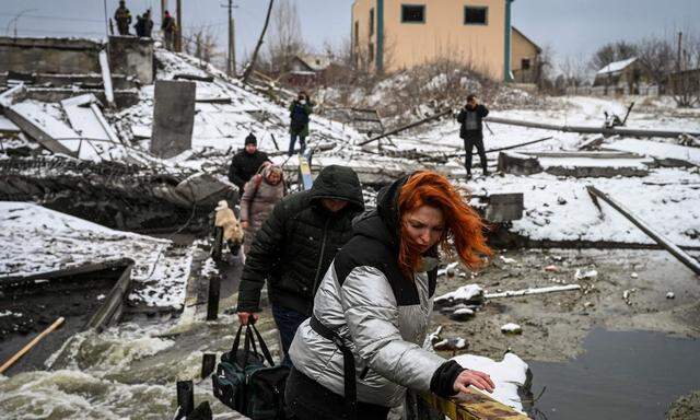 Zivilisten überqueren einen Fluss bei Kiew – die Brücke wurde in die Luft gesprengt.